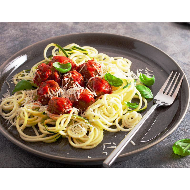 A delectable plate of ketogenic konjac pasta adorned with savory meatballs and generous shavings of Parmesan cheese, presented on a stylish dining table.